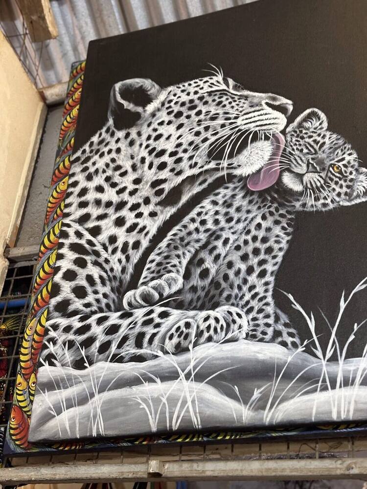 Black and white painting of two leopards with colorful border, original Tanzanian art